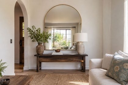 Cómo usar espejos en casa para ganar amplitud y luminosidad sin complicaciones 10 Salon luminoso con espejo arqueado y plantas