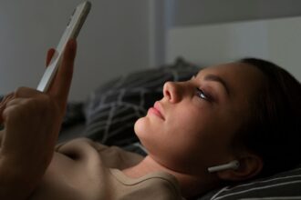 Dormitorios sin reloj ni pantallas: la tendencia del “sleep sanctuary” que redefine el descanso 7 mujer smartphone